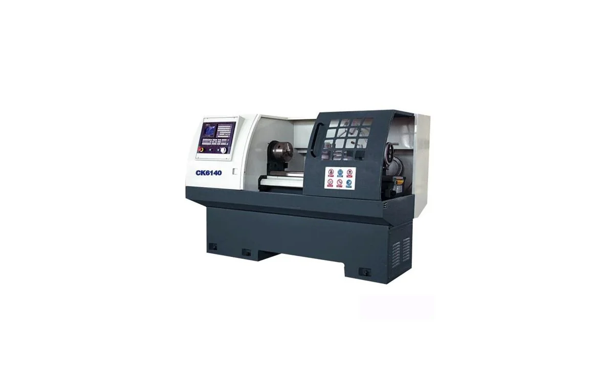 Torno CNC horizontal de bancada plana Taikan CK6140 mecanizando eje de acero entre plato y contrapunto